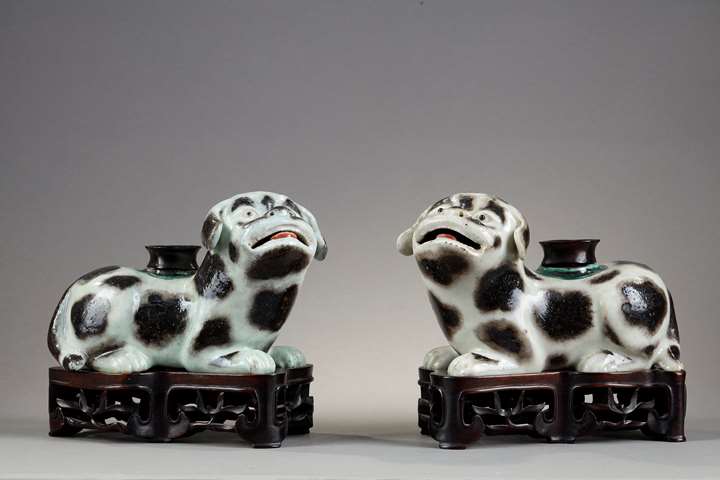 Pair of dogs forming incense stick holders in brown speckled porcelain on beige background